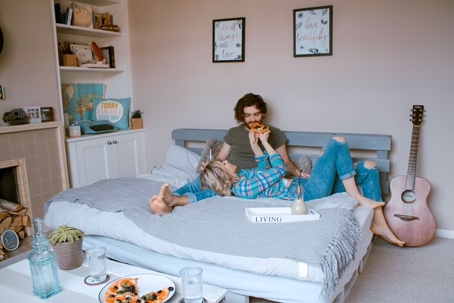 woman feeding man on a bed