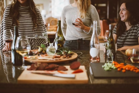3 women around a table drinking wine